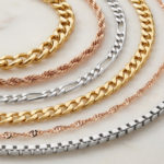 Types mailles chaînes : trouvez le style parfait 3 Elegant display of gold, silver, and rose gold jewelry chains including Forçat, Corde, Figaro, Singapour, and Vénitienne.