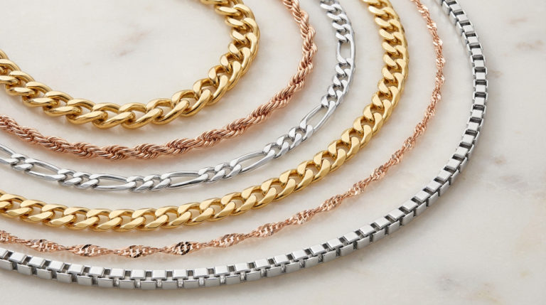 Elegant display of gold, silver, and rose gold jewelry chains including Forçat, Corde, Figaro, Singapour, and Vénitienne.