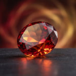 Grenat vertus : ravivez votre énergie et votre passion 3 Photorealistic crimson garnet gemstone with orange/gold glows, centered on dark stone, blurred red/orange/gold aura background.