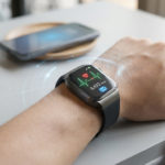 Fonctionnement montre connectée : secrets d'une alliée 4 Modern smartwatch on wrist displays heart rate, steps, and notifications, connected to a blurred smartphone by blue digital lines.
